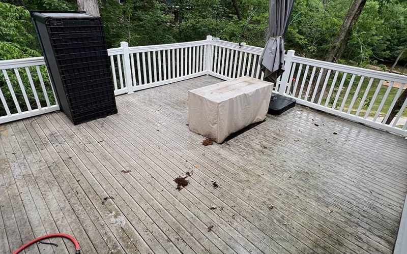deck with patio items with white fencing before cleaning